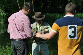 A man being taught how to fly fish.